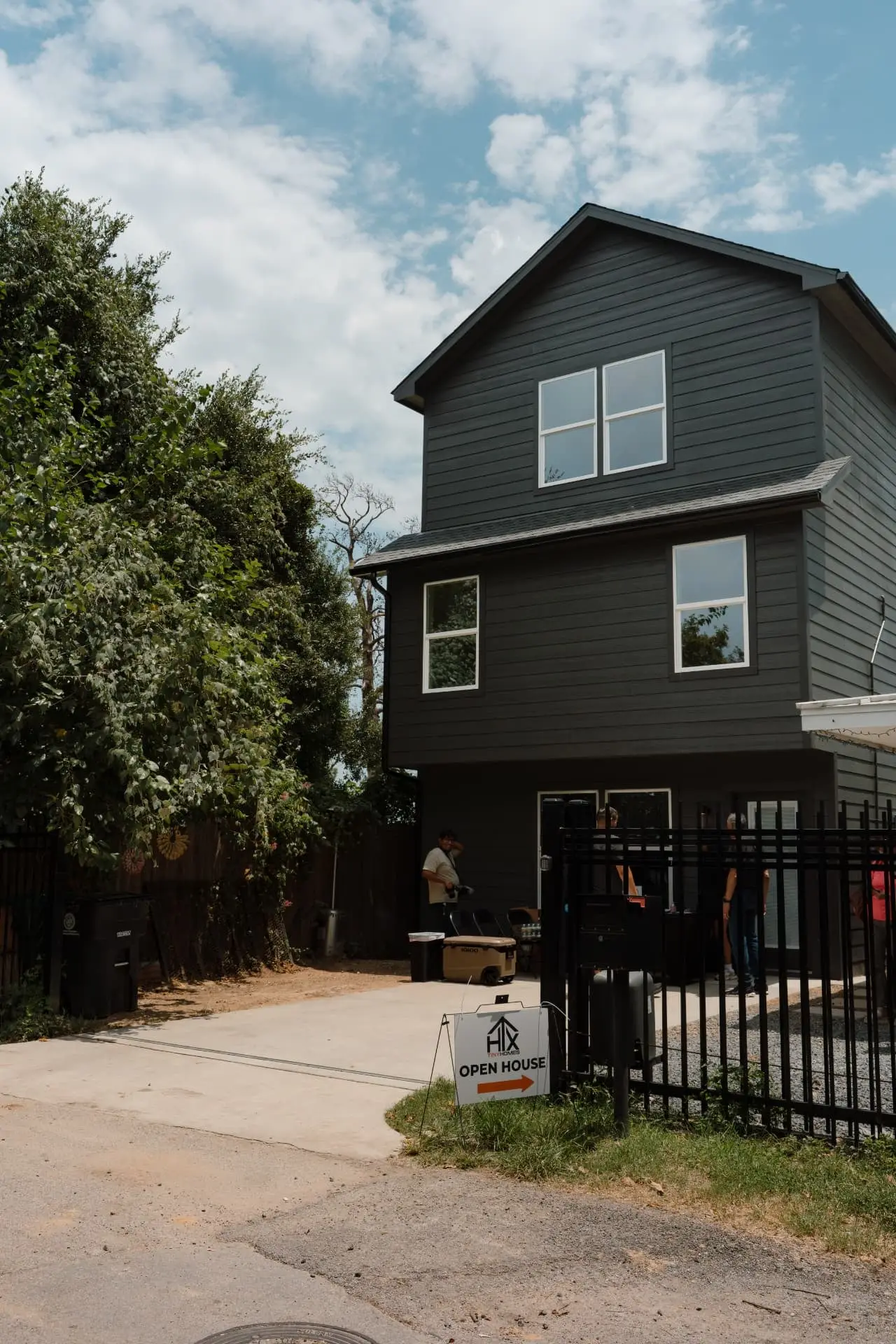 Two-story black backyard tiny home built by HTX Tiny Homes